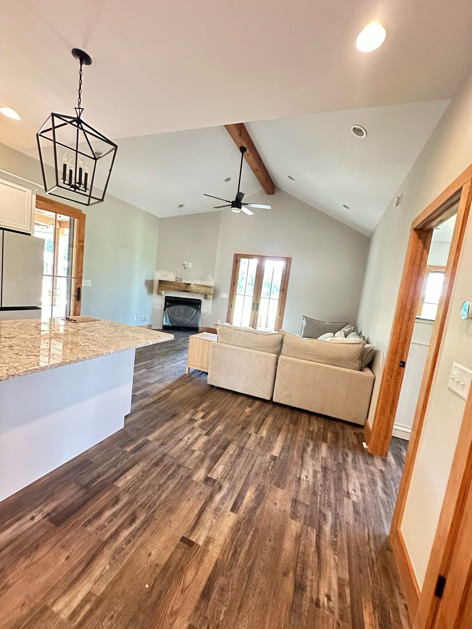 Finished living room with vaulted ceiling and wood floors
